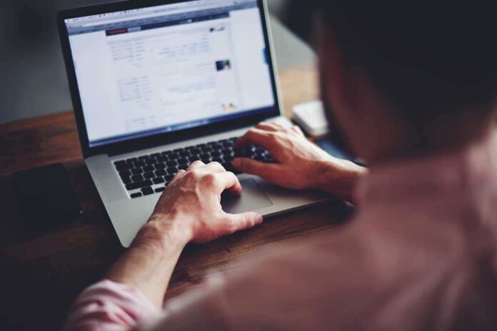 Cropped,Image,Of,A,Young,Man,Working,On,His,Laptop