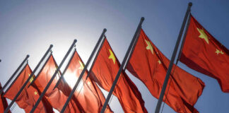 Chinese flags waving under a clear sky.