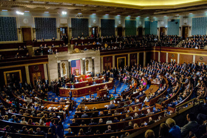 shutterstock_1186368262.jpg featured image Full chamber meeting with numerous attendees and speakers.