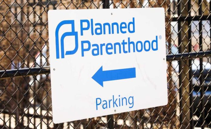 shutterstock_2278620489.jpg featured image Planned Parenthood parking sign on chain fence