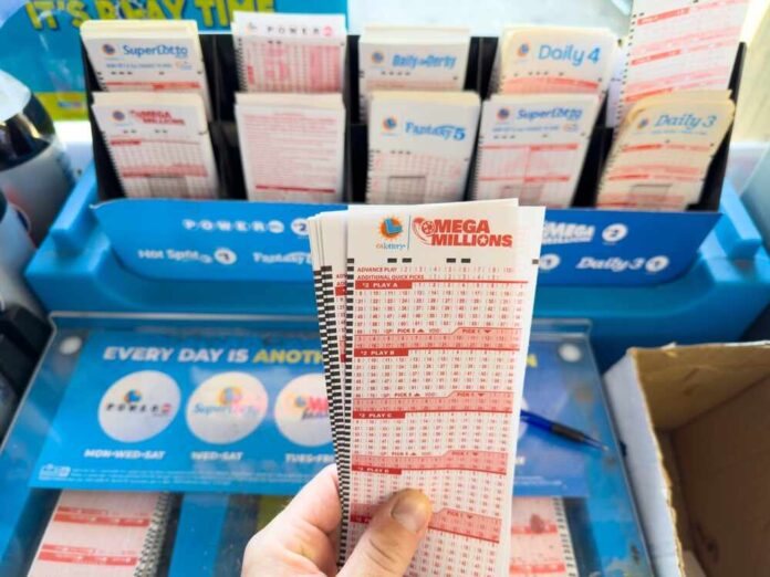 shutterstock_2373788915.jpg featured image Hand holding a Mega Millions lottery ticket display