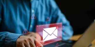 Person typing on laptop with mail warning icons.