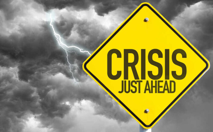 shutterstock_327481232.jpg featured image Yellow sign reading Crisis Just Ahead with stormy sky