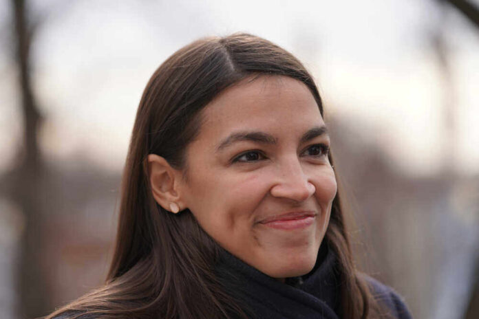 shutterstock_1611673927.jpg featured image Alexandria Ocasio-Cortez, or AOC, smiling woman with long hair.