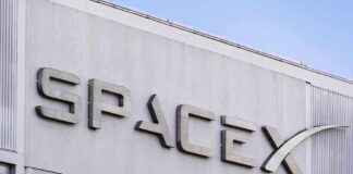 SpaceX building logo against blue sky.