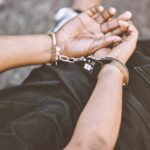 Person in handcuffs with hands behind back.