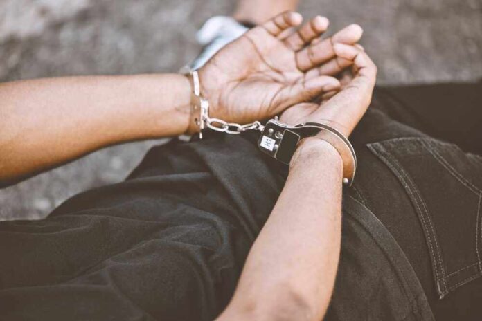 shutterstock_2224946127.jpg featured image Person in handcuffs with hands behind back.