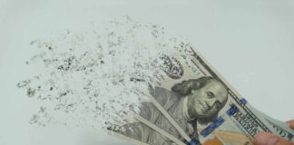 Hundred dollar bills disintegrating in hand