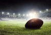 Football on field in illuminated stadium at night