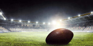 Football on field in illuminated stadium at night