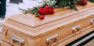 Wooden casket with red roses on top