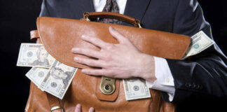 Person holding briefcase with money protruding from it