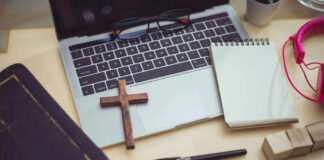 Bible, cross, laptop, notebook, pen, and headphones
