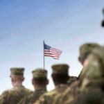 Soldiers in uniform with American flag