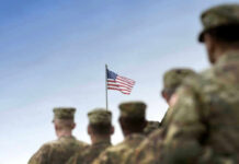 Soldiers in uniform with American flag