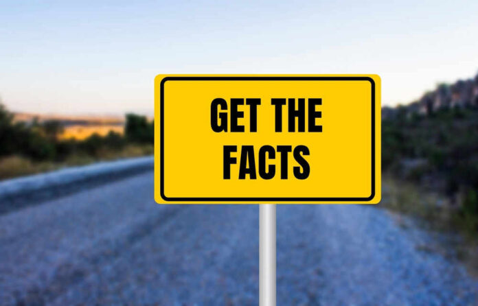 Yellow sign reads Get the Facts on road