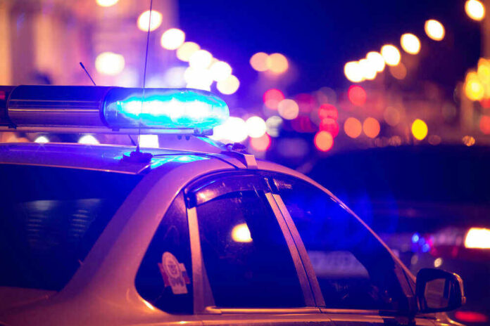 Police car with blue lights flashing at night