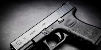 Black Glock 19 pistol on a dark surface