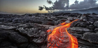 Flowing lava on dark volcanic rock landscape