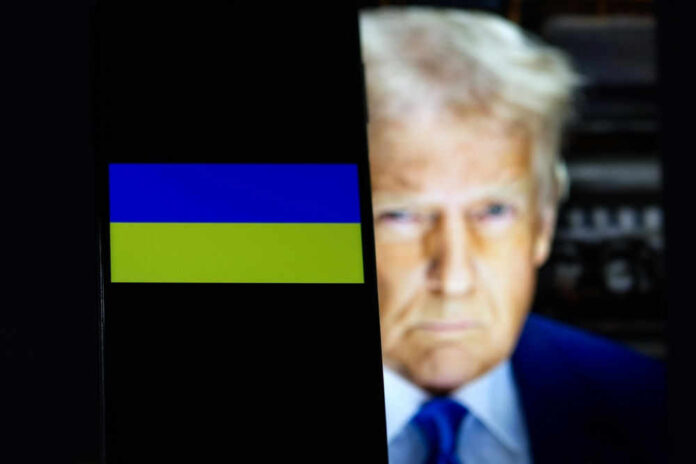 Ukraine flag on smartphone with President Donald Trump behind it