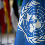 Trump BYPASSES UN With Bombshell New Requirement United Nations flag with other flags in background.