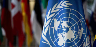 United Nations flag with other flags in background.