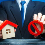 Surprise Move: Trump Targets Housing Giants Businessman holding house model and prohibition sign