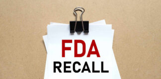 A notice labeled 'FDA RECALL' clipped to white papers on a brown background