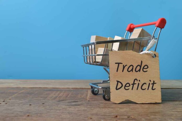 A shopping cart with wooden blocks and a sign reading 'Trade Deficit'