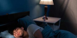 A young man sleeping peacefully in a dimly lit bedroom