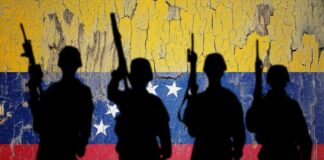 Silhouettes of soldiers in front of the Venezuelan flag