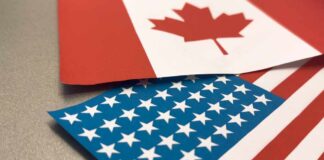 Canadian and American flags overlapping on a surface