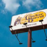 Cracker Barrel’s Menu Comeback — Loyalty Wins Sign for Cracker Barrel restaurant against a blue sky