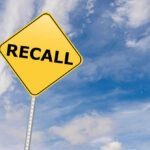 Engine Fire Scare: Huge Recall Yellow sign with RECALL text against blue sky.