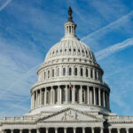 Congress TORPEDOES Trump Budget Cuts U.S. Capitol building dome against blue sky.