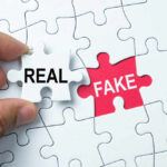 Fake Chocolate Scandal ROCKS Iconic Candy Giant A hand holding a white puzzle piece labeled 'REAL' next to a red puzzle piece labeled 'FAKE'