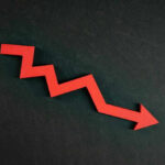 Red zigzag arrow pointing down on dark background.