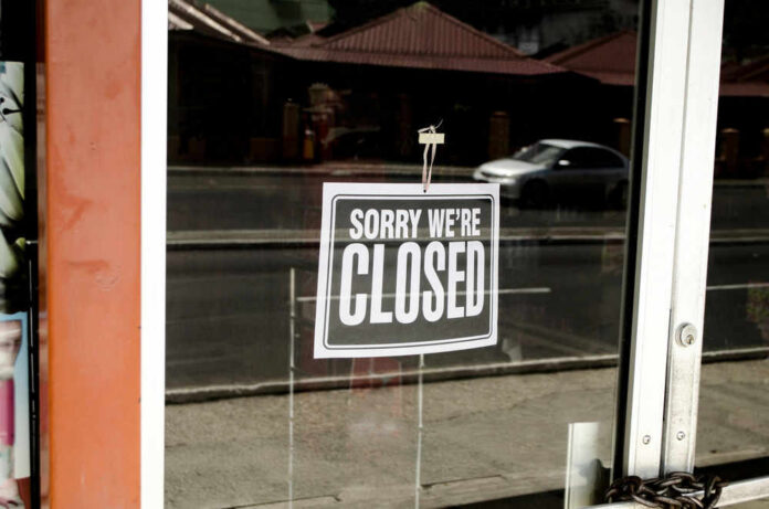Closed sign hanging on a glass door