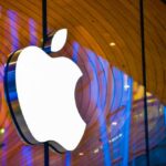 Illuminated Apple logo against a wooden backdrop