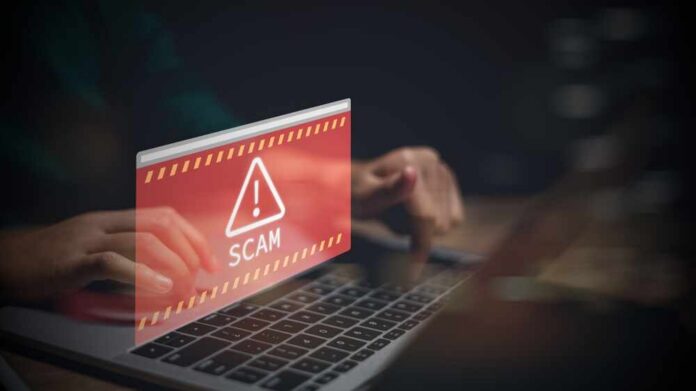 Warning message about a scam displayed on a laptop screen