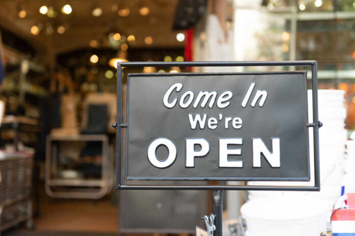 A black sign with white text that says 'Come In We're OPEN'