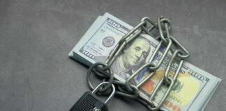 A stack of cash secured with a chain and padlock