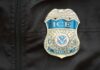 Close-up of an ICE officer badge on a black jacket