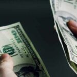 Hands holding and counting stacks of cash