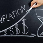 Dimon Warns Of Massive Inflation Threat Chalkboard drawing of inflation with rising dollar symbols.