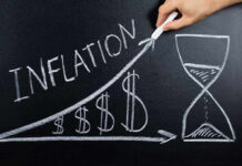 Chalkboard drawing of inflation with rising dollar symbols.
