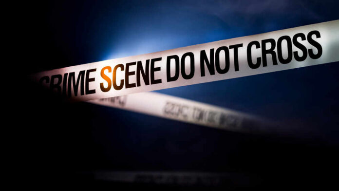 shutterstock_1677725647.jpg Police tape reading 'CRIME SCENE DO NOT CROSS' in a dark setting