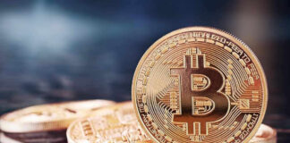 Bitcoin coins on a reflective surface.