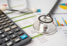Calculator and stethoscope on financial documents