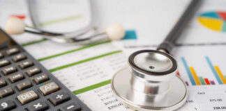 Calculator and stethoscope on financial documents